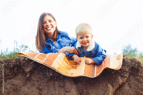 mother and son lying on the grass photo