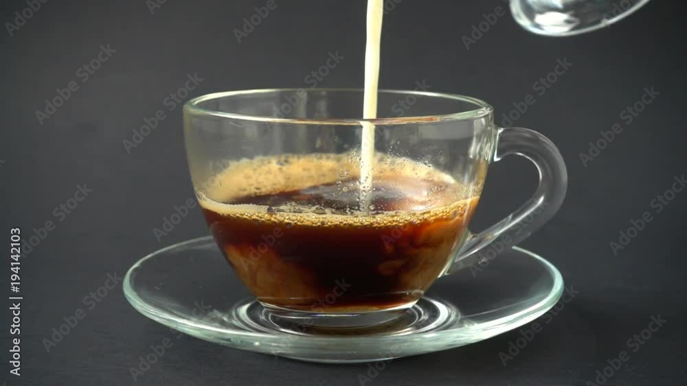 Preparation of a cappuccino, milk is poured in a cup with coffee. Slow Motion. Preparation of a cappuccino, milk is poured in a cup with coffee. Slow Motion.