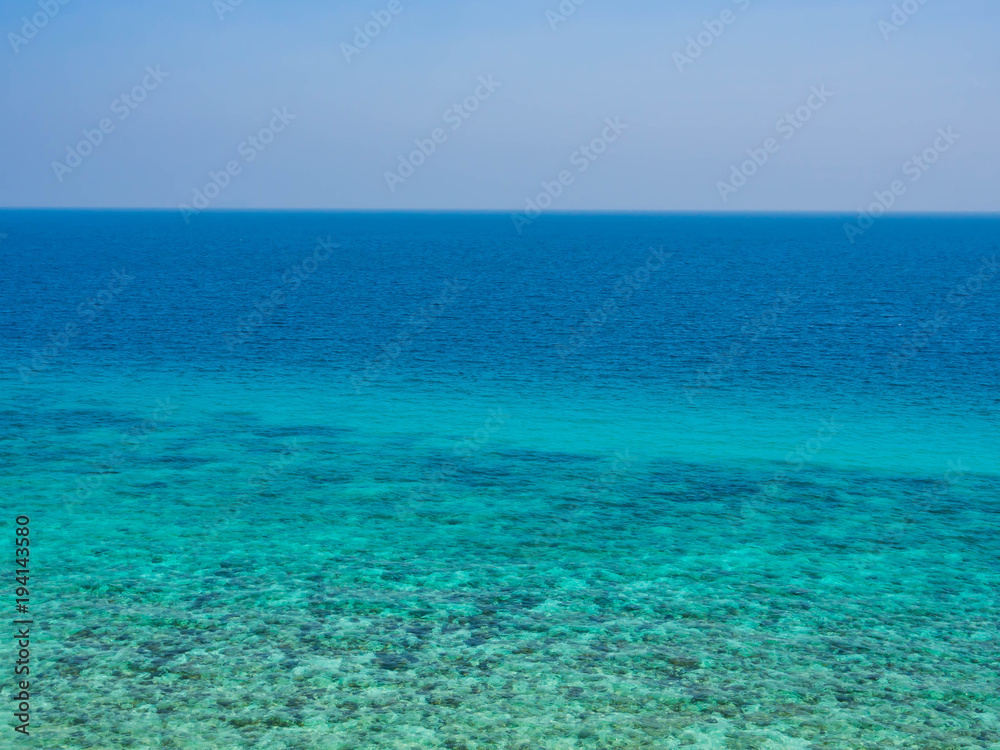 Abstract nature background. Clear blue sky and turquoise sea with coral reef.