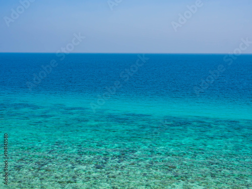Abstract nature background. Clear blue sky and turquoise sea with coral reef.