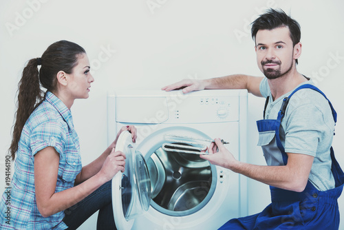 Repairman is repairing a washing machine for housewife. White background