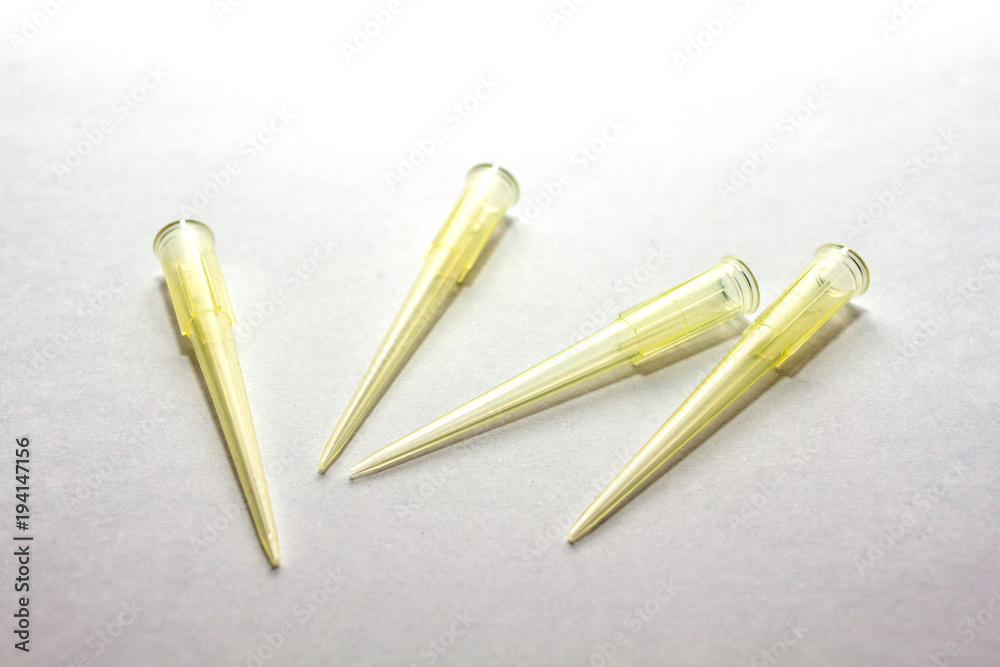 A yellow disposable micro pipette tips for lab or laboratory on white background A yellow disposable micro pipette tips for lab or laboratory on white background