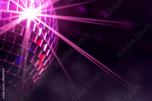 Disco ball with violet star burst and fog in club