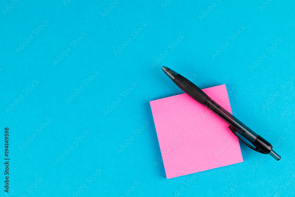 black pen with pink post on blue background black pen with pink post on blue background