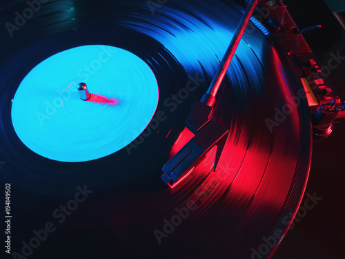 Cinemagraph, retro record vinyl player. Record on turntable. Top view close up. Loop-able Vintage photo of Old Gramophone, playing a music. Neon light photo