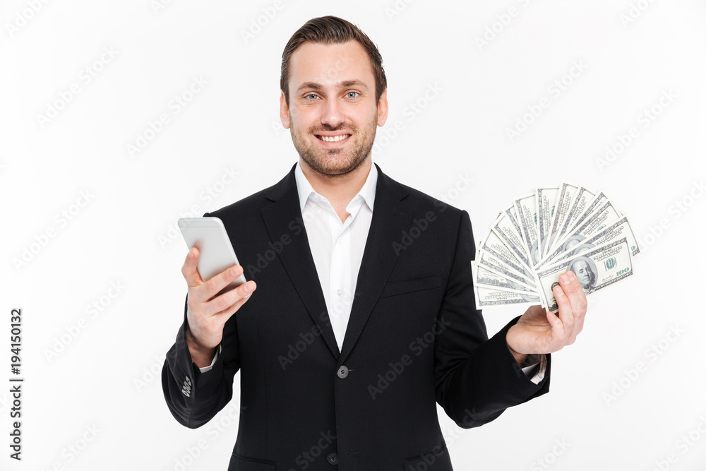 Φωτογραφία Portrait of positive man in suit smiling while holding fan of money dollar curre