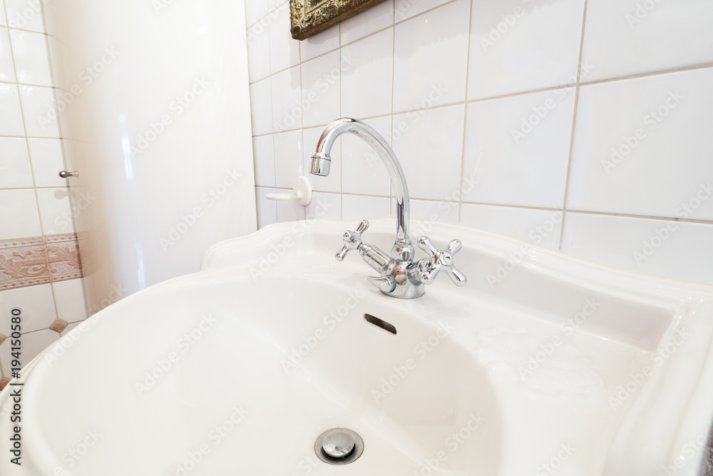 detail of classic faucet and white sink detail of classic faucet and white sink