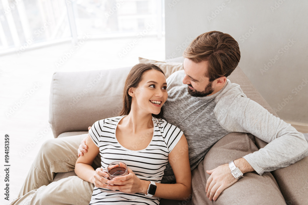 Portrait of a happy young couple together on a couch at home Portrait of a happy young couple together on a couch at home