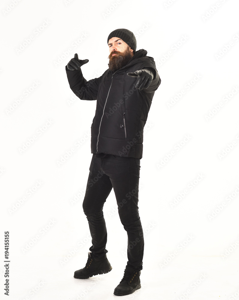 Hipster with strict face wears warm clothes and points forward. Hipster with strict face wears warm clothes and points forward.