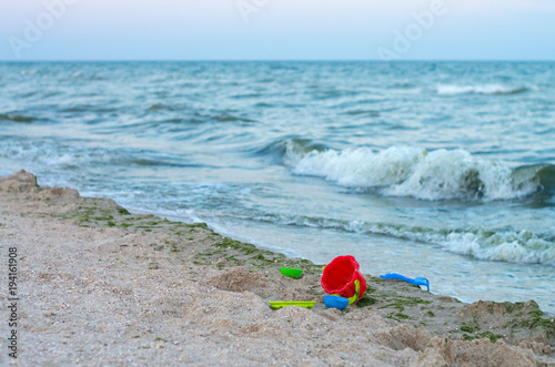 plastic children's toys on the sea beach, a storm