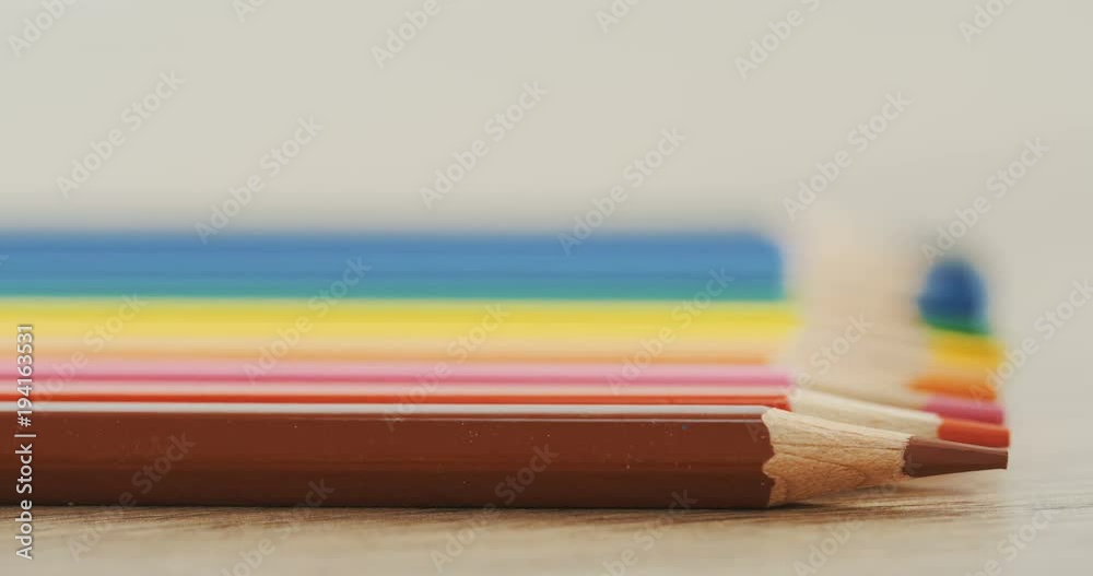 Macro of the colourful pencils lying on the wooden desk in the line and becoming blurred. Close up Macro of the colourful pencils lying on the wooden desk in the line and becoming blurred. Close up