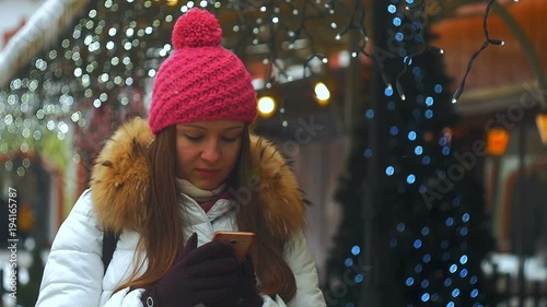 Young woman smile face in winter city. Using phone photo