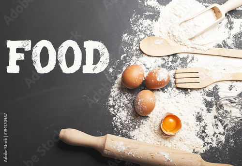 Background of ingredients for cooking on black background with the word Food on top. Food Concept photo