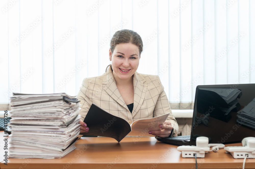 Welcoming receptionist a woman looking at camera with schedule or list Welcoming receptionist a woman looking at camera with schedule or list
