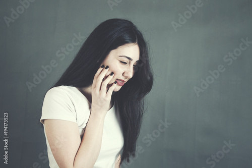 woman hand on tooth on dark background