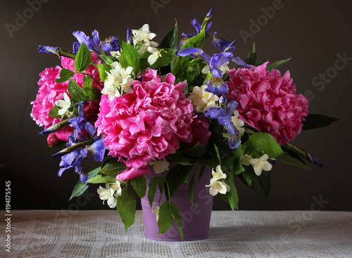 Peonies, irises and Jasmine in a bouquet. Garden flowers in a vase.