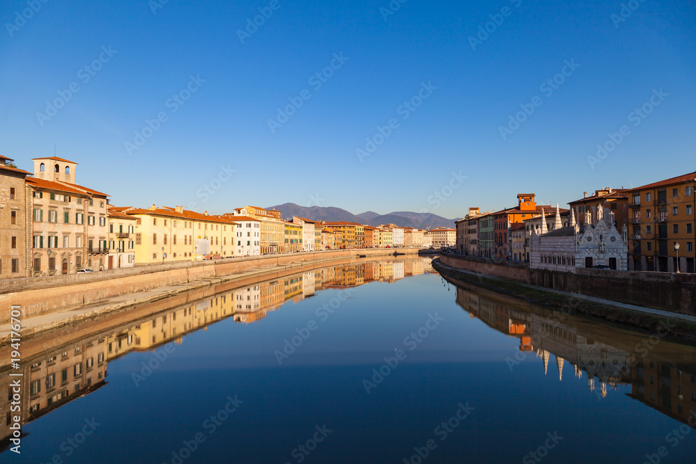 Arno river embankment with colorful old houses and Santa Maria della Spina church. Picturesque medieval town of Pisa, Tuscany, Italy.