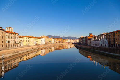 Arno river embankment with colorful old houses and Santa Maria della Spina church. Picturesque medieval town of Pisa, Tuscany, Italy.