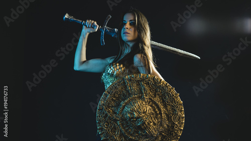 Fotografie valkyrie warrior, woman with golden armor iron coat and big warrior sword