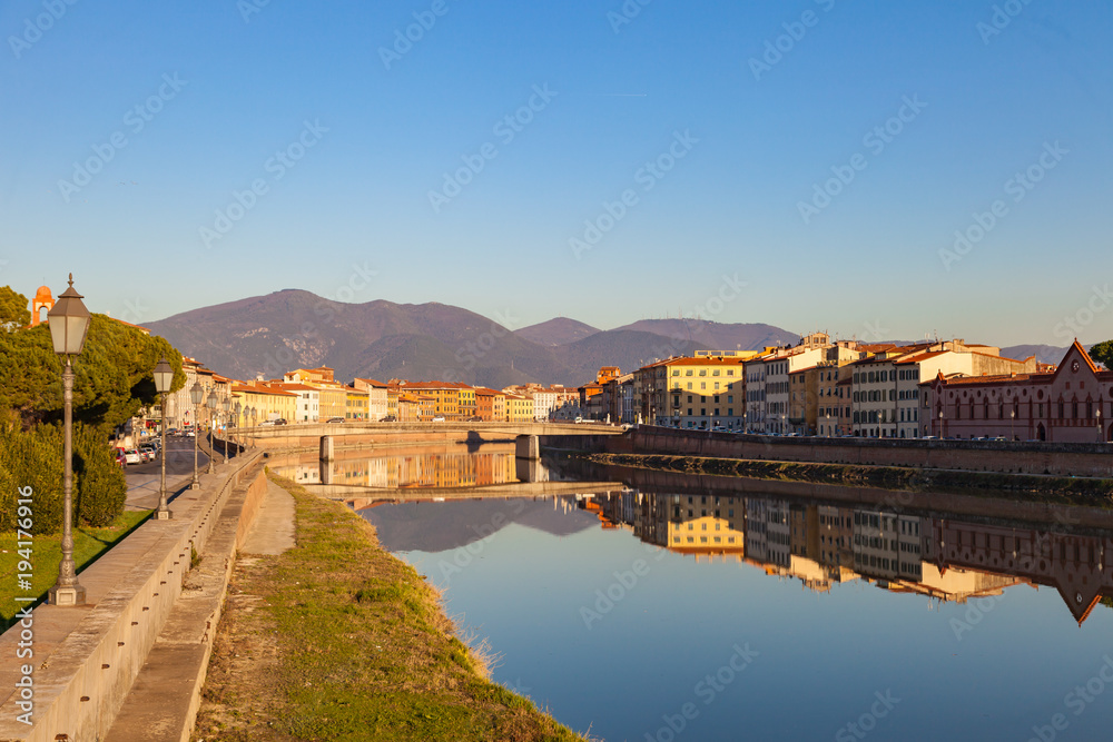Arno river embankment with colorful old houses, view from Ponte della Citadella. Picturesque medieval town of Pisa, Tuscany, Italy.