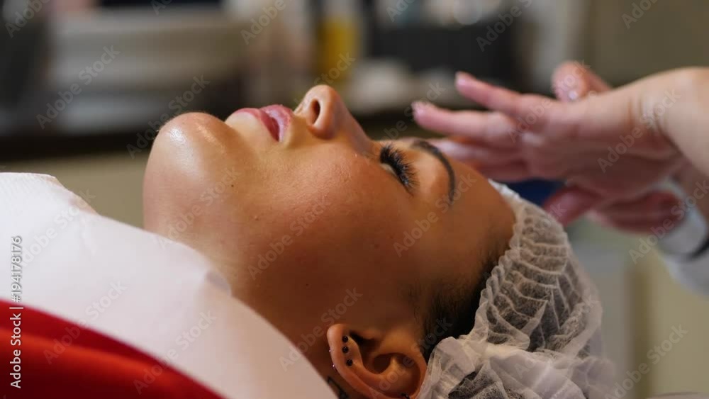 Cosmetologist is going face mask . peeling for young woman. Woman is having cosmetology procedure Cosmetologist is going face mask . peeling for young woman. Woman is having cosmetology procedure