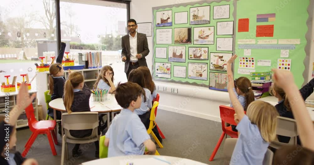 4k, Primary school teacher and students in classroom during lesson ...