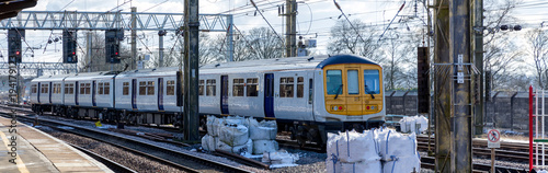 a white commuter train arrives at the station