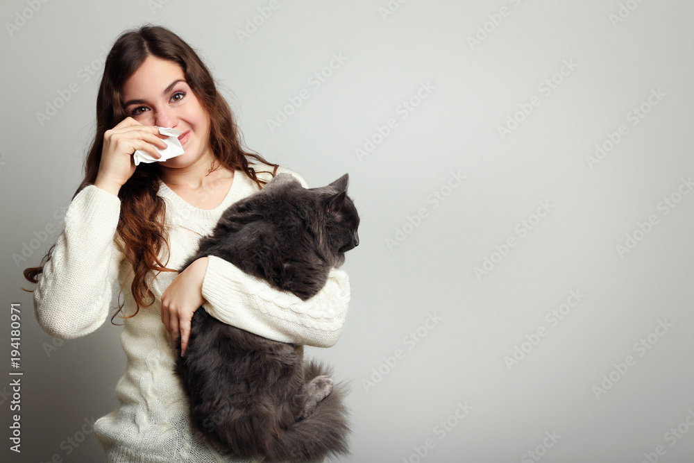 Young woman with allergy holding cat on grey background - obrazy, fototapety, plakaty 