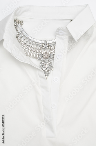silver necklace with diamonds on the collar of a white shirt