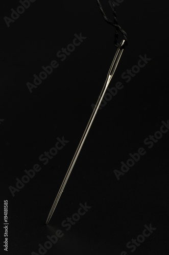 needle and thread macro isolated on black © vitaly tiagunov