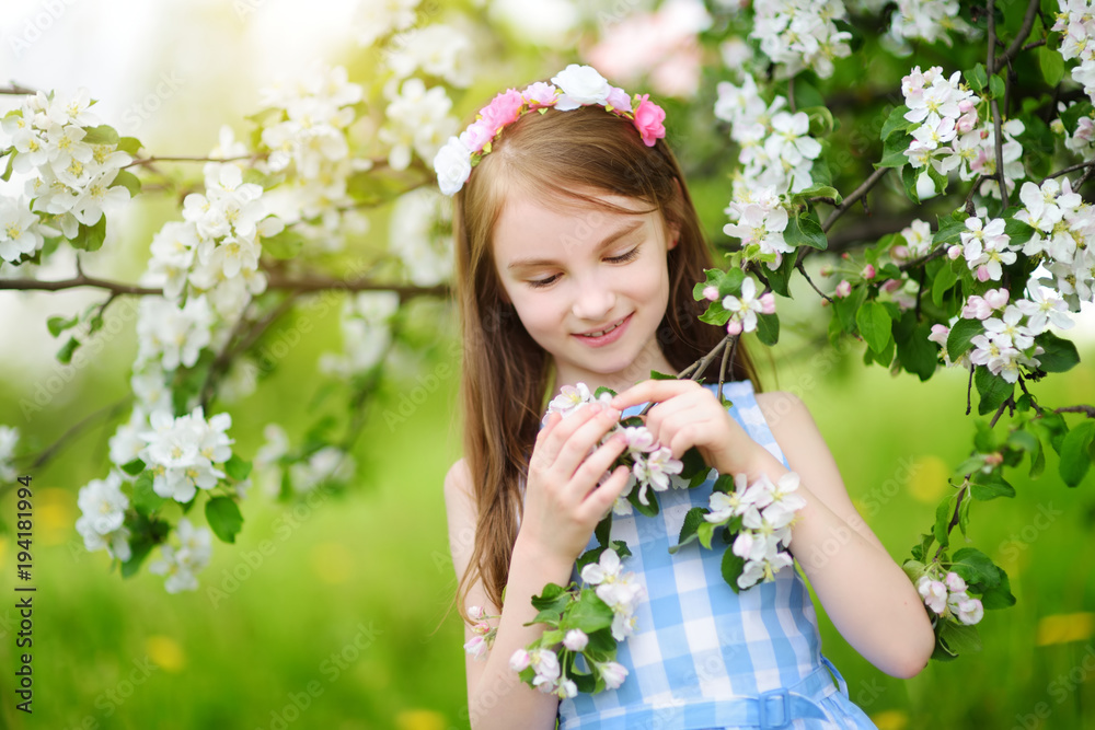 Adorable little girl in blooming apple tree garden on beautiful spring day Adorable little girl in blooming apple tree garden on beautiful spring day