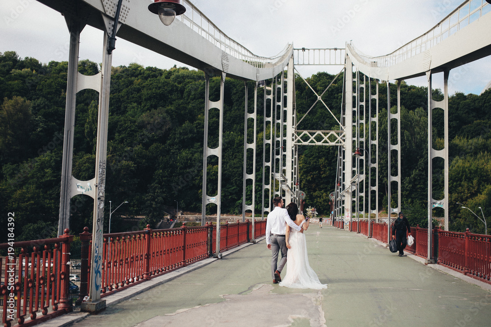 The lovely couple in love walking along  bridge