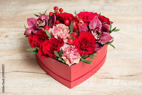 Fototapeta Naklejka Na Ścianę i Meble -  Red gift box with flowers at wooden desk