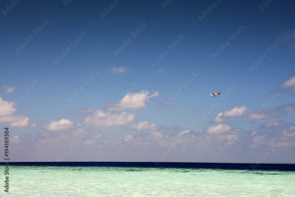 Small sea airplane flying above paradise tropical sea Small sea airplane flying above paradise tropical sea