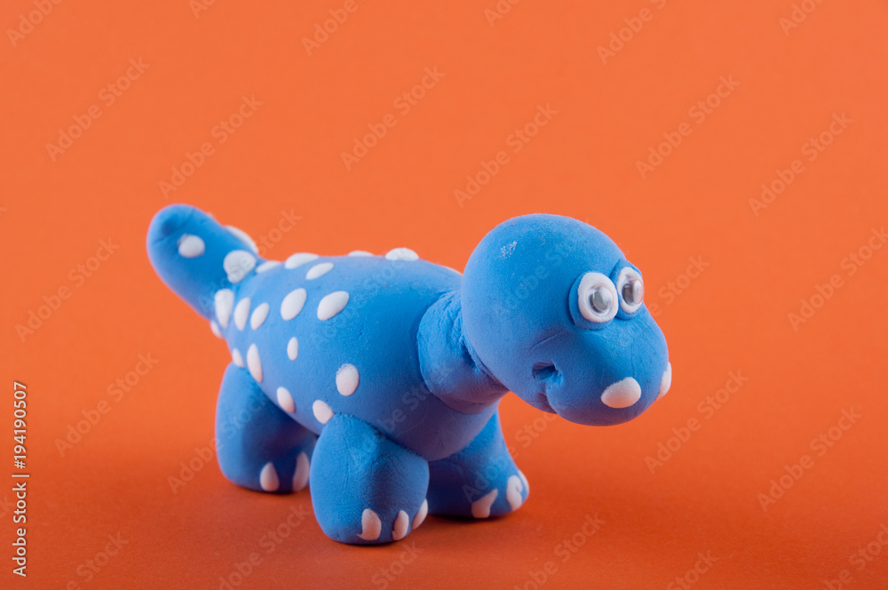 Camarasaurus. Blue dino model made of plasticine on orange background Camarasaurus. Blue dino model made of plasticine on orange background