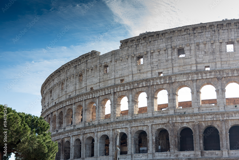 detail view of historic colosseum in rome italy on sunny day and clouds
