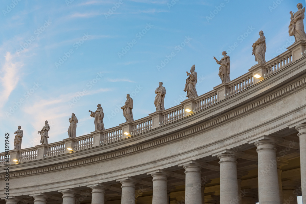 lineup of roman statues at St Peter's square in Rome Italy on gallerie with pillars