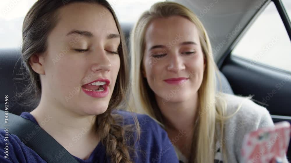 Happy Young Women Pose For Cute And Funny Selfies In Back Seat Of Moving Car, They Scroll Through Them And Laugh - Shot On Red Scarlet-W Dragon In 4k/Slow Motion Happy Young Women Pose For Cute And Funny Selfies In Back Seat Of Moving Car, They Scroll Through Them And Laugh - Shot On Red Scarlet-W Dragon In 4k/Slow Motion