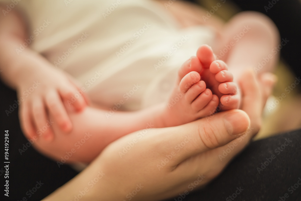little newborn baby feet in mom's suppoting hands