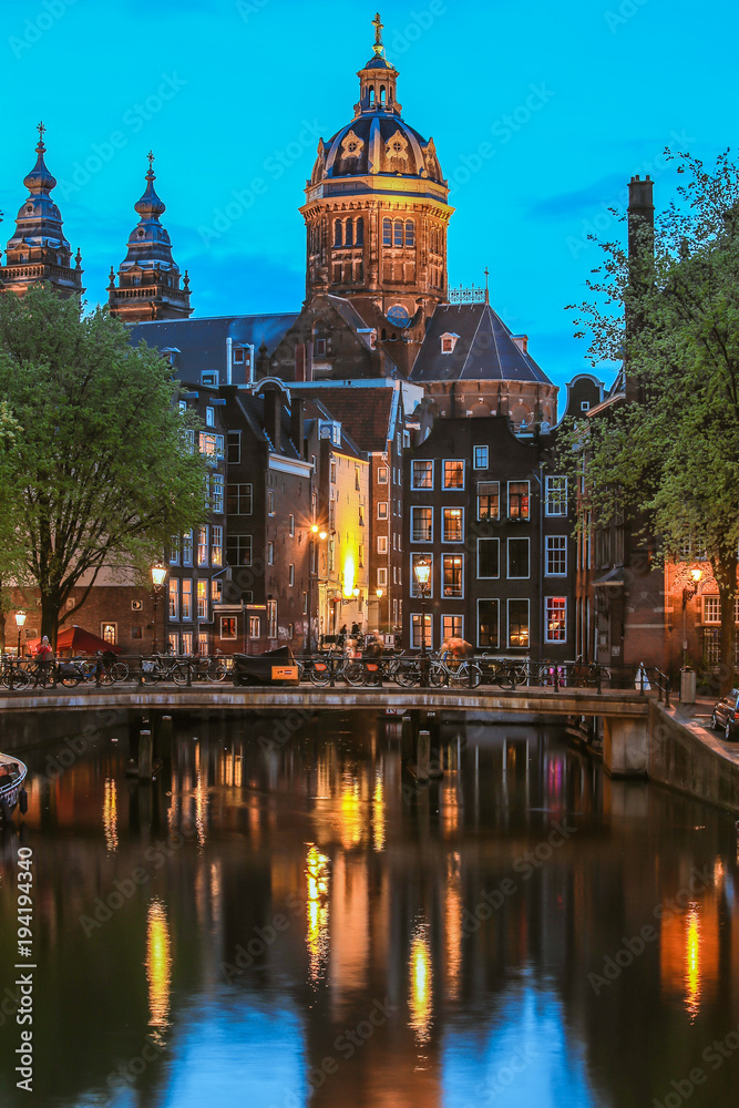 Canal and St Nicolas Church in Amsterdam at twilight, Netherlands