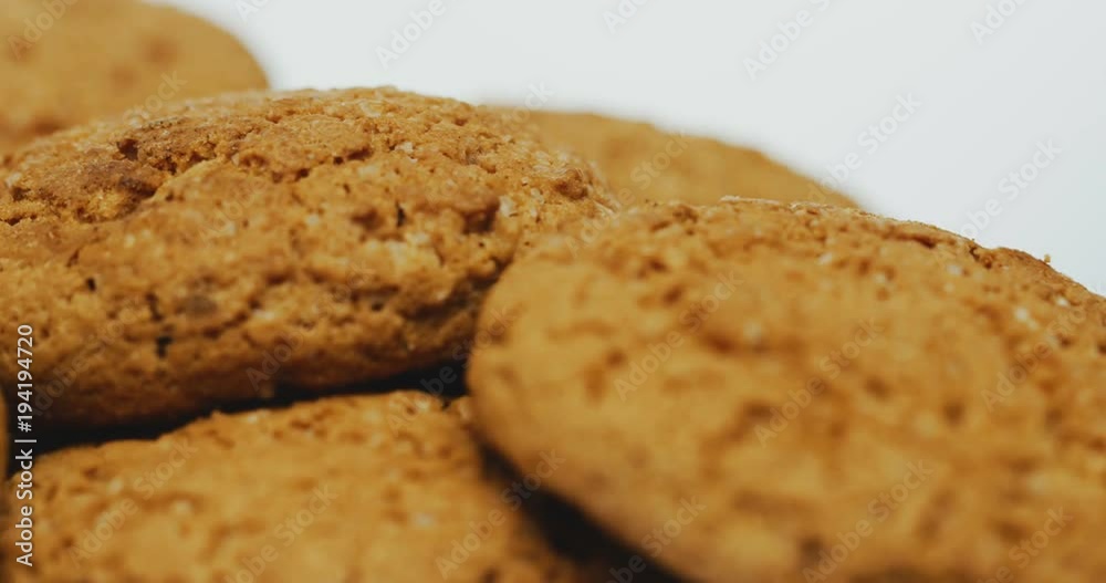 Macro shooting of the cookies rolling in front of the camera on the white background. Close up Macro shooting of the cookies rolling in front of the camera on the white background. Close up