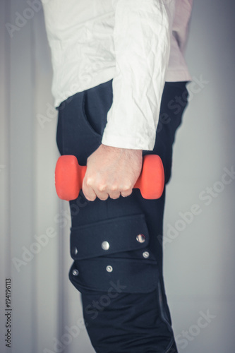 Unrecognizable athlete holding dumbbells.