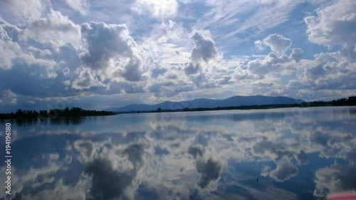 The lake has a reflection of the clouds and the sky.  photo