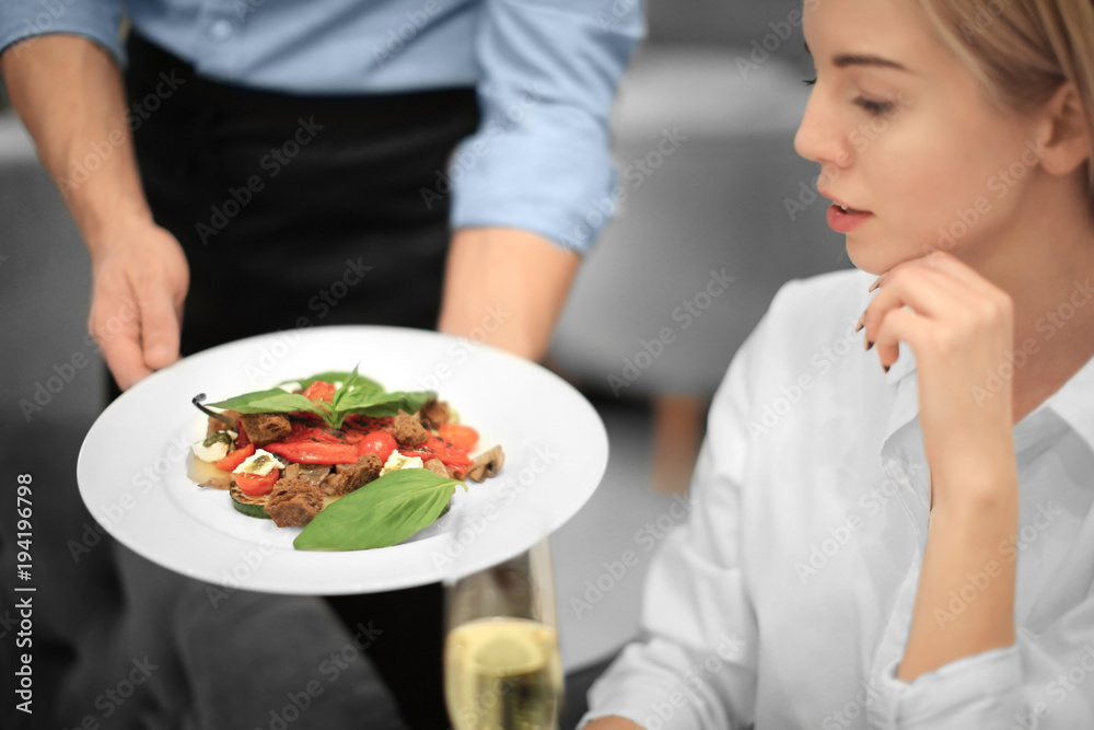 Young waiter serving vegetable salad in cafe Young waiter serving vegetable salad in cafe
