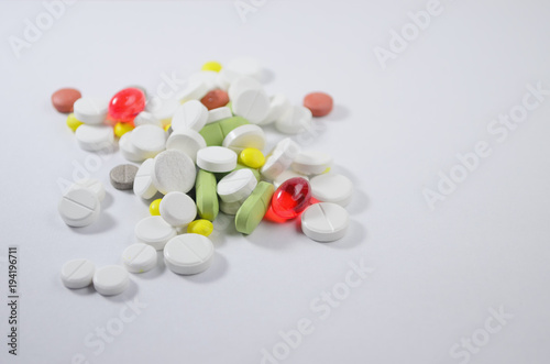 White surface with colorful pills and capsules. Mock up