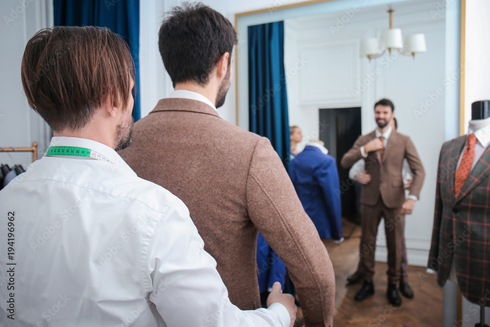 Obraz premium Tailor with client in atelier. Sewing custom made suit