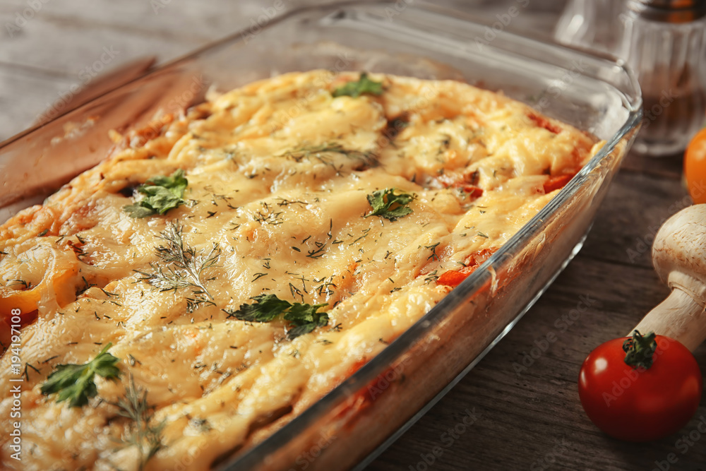 Glass baking dish with delicious casserole on table, closeup. Fresh from oven Glass baking dish with delicious casserole on table, closeup. Fresh from oven