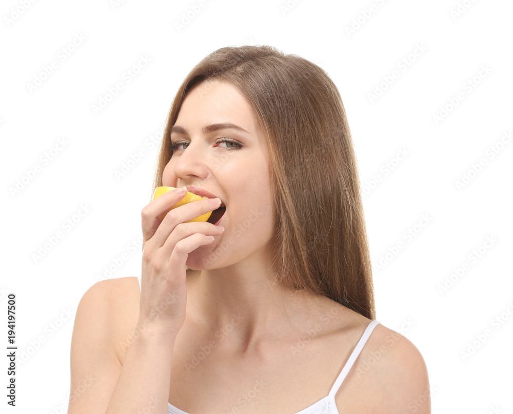 Beautiful young woman eating ripe lemon on white background Beautiful young woman eating ripe lemon on white background