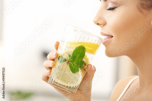 Beautiful young woman drink...