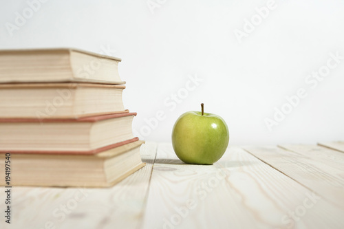 Stack of books and apple on the table. Copy space for text. Selective focus. Knowledge concept